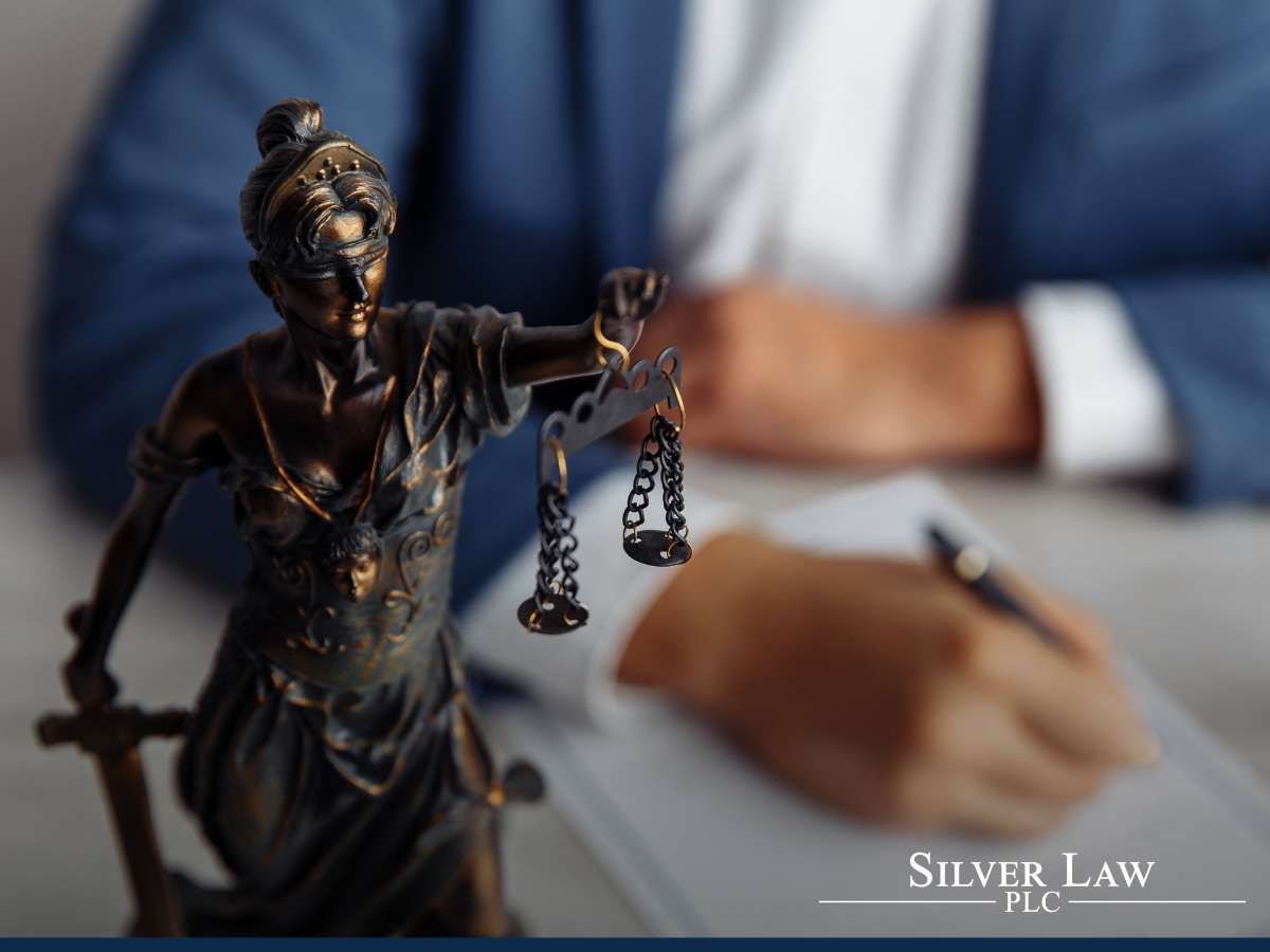 Lady Justice statue with scales with a tax lawyer in background