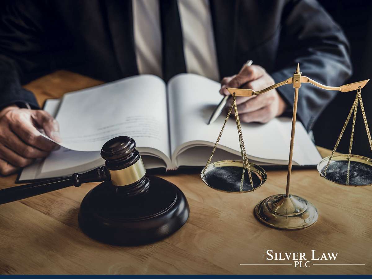 Gavel and scales of justice on a lawyer's desk with an open book, representing Supreme Court matters at Silver Law, PLC